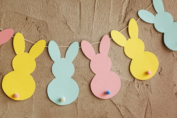 Гирлянда с красочными бумажными кроликами на сером фоне. Пасхальная концепция — стоковое фото