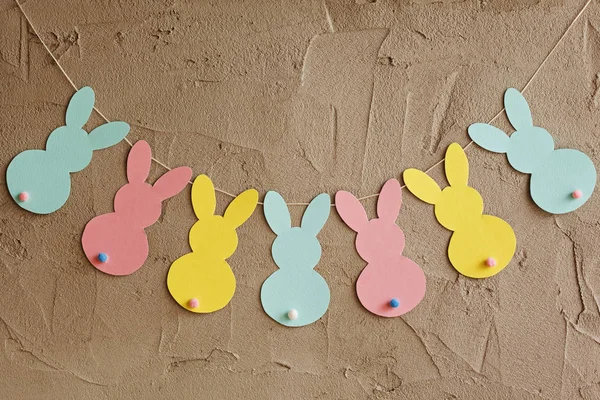 Гирлянда с красочными бумажными кроликами на сером фоне. Пасхальная концепция — стоковое фото