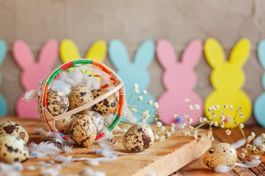 Paskalya Paskalya bıldırcın yumurtası sepet ve ahşap arka plan üzerinde tavşan garland ile bileşimi.
