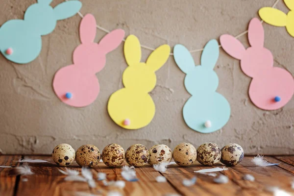 Пасхальная композиция пасхальных перепелиных яиц в корзине и с венком кролика на деревянном фоне . — стоковое фото