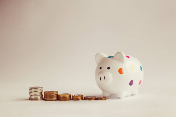 White piggy bank or money box with money coins.