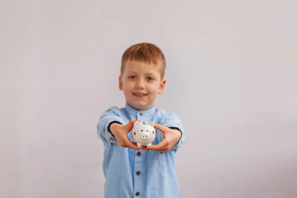 Cute little boy holding a piggy bank or money box — Stock Photo, Image