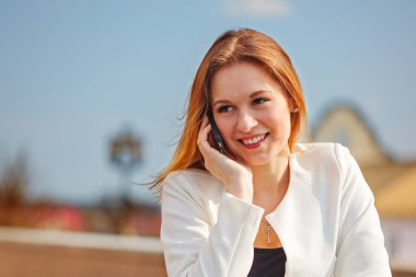 Genç mutlu kadın cep telefonuyla konuşuyor.