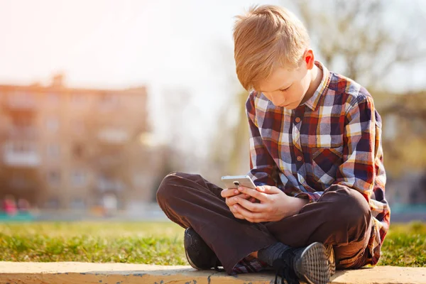 Bambino che gioca telefono all'aperto nella giornata di sole . — Foto Stock