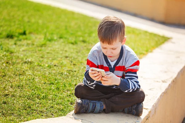 Kind spielt bei sonnigem Tag im Freien telefonieren. — Stockfoto