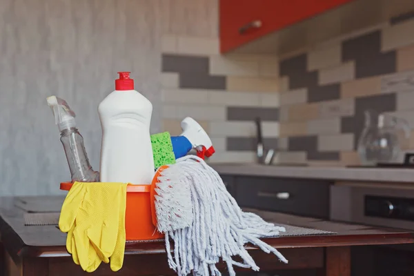 Juego de limpieza con productos y suministros en la mesa de la cocina — Foto de Stock