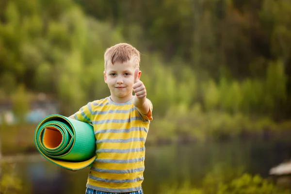 Cute boy doing sports on nature background. Sporty little boy doing exercises in the summer park. Kid smiling, shows a class — Stock Photo, Image