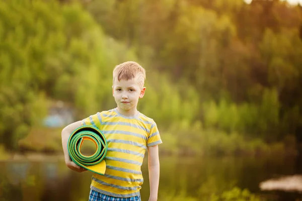 Netter Junge, der Sport auf dem Hintergrund der Natur macht. Sportlicher kleiner Junge beim Turnen im Sommerpark. — Stockfoto