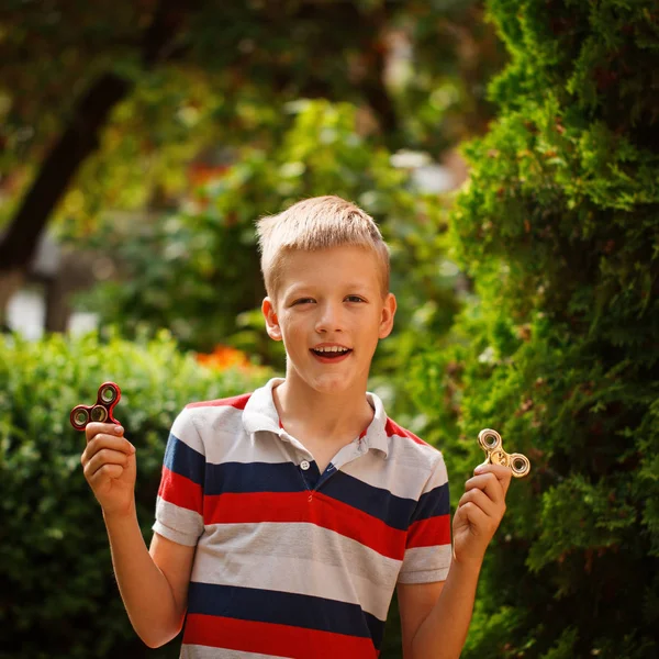 Teenager spielen an Sommertagen mit Fidget-Hand-Spinnern. beliebtes und trendiges Spielzeug für Kinder und Erwachsene. — Stockfoto
