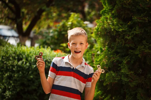 Tiener speelt met fidget hand spinners in zomerdag. Populaire en trendy speelgoed voor kinderen en volwassen. — Stockfoto