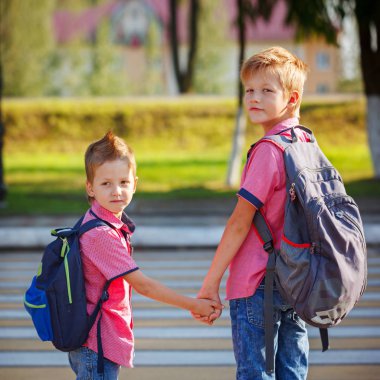 Portrait two adorable boys with backpack near pedestrian crossin. clipart