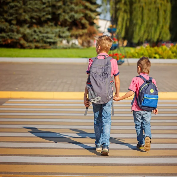 Two boys with backpack walking, holding on warm day on the road. — Stock Photo, Image