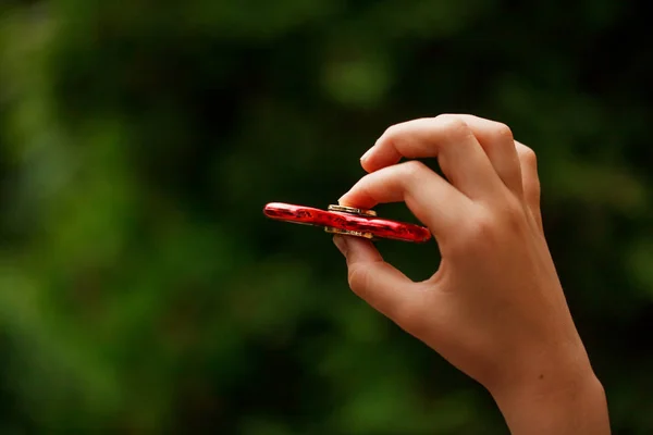 Nahaufnahme Kinder Hand in Hand mit zappelnden Handspinnern. trendiges und beliebtes Spielzeug für Kinder und Erwachsene — Stockfoto