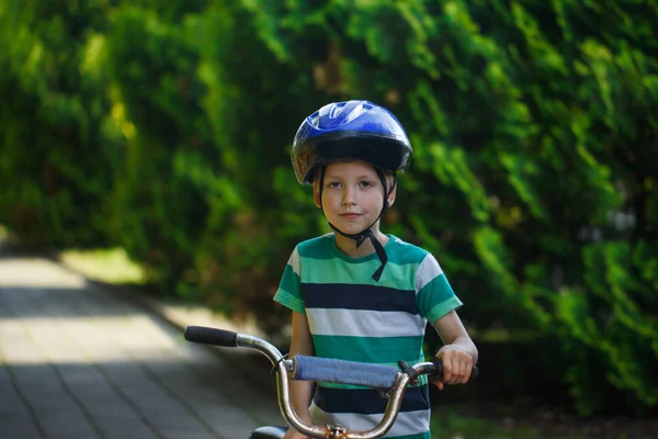 Retrato Niño en una bicicleta en la carretera de asfalto en el parque . — Foto de Stock