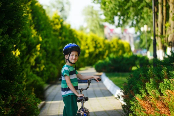 Portret uśmiechnięty chłopiec dziecko na rowerze o asfalt w parku — Zdjęcie stockowe