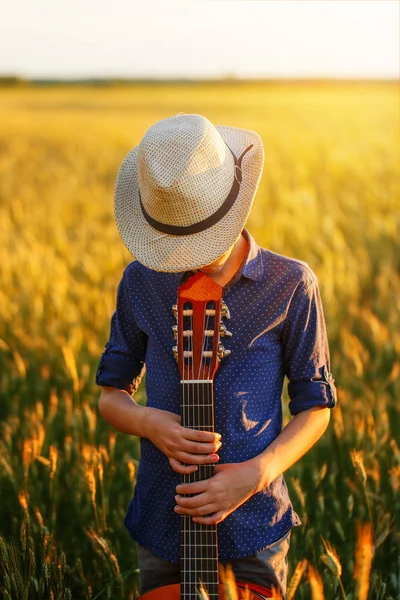 Tonårspojke i hatt med akustisk gitarr — Stockfoto