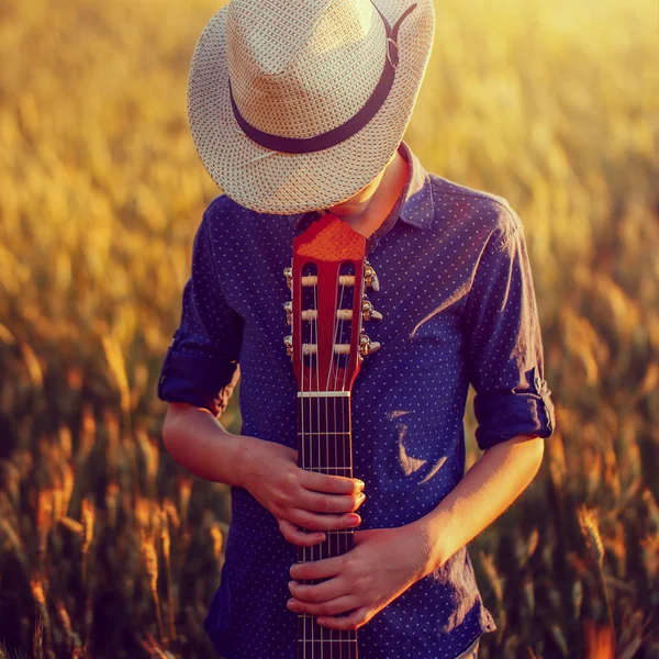 Teenage boy in hat with acoustic guitar, outdoors — Stock Photo, Image