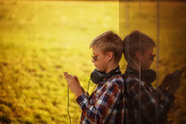 音楽を聴くと、電話を使用してハンサムな 10 代の少年 — ストック写真