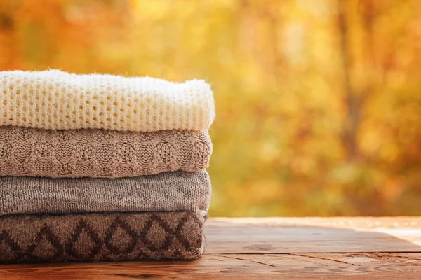 stock image Stack pile of knitted autumn clothes on nature background.