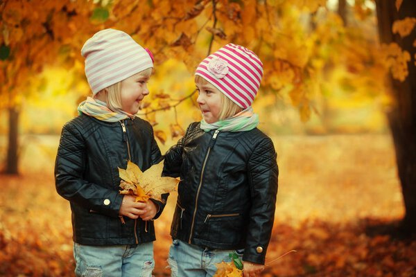 Портрет Две прелестные маленькие сестры в осеннем парке с листьями
.