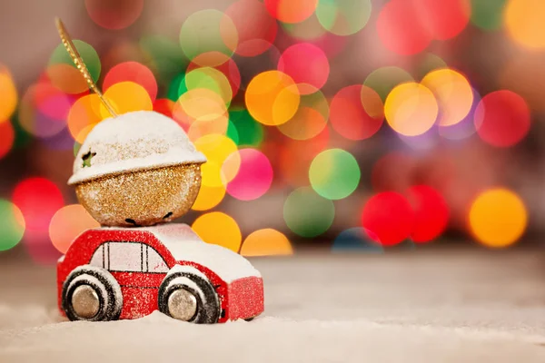 Minyatür kırmızı araba taşıyan renkli bokeh arka plan çatıda bir hediye.