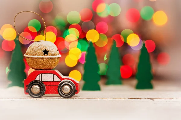 Minyatür kırmızı araba taşıyan renkli bokeh arka plan çatıda bir hediye.