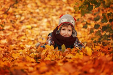 Sonbahar yaprakları Park çocuk yatıyor mutlu gülümseyerek