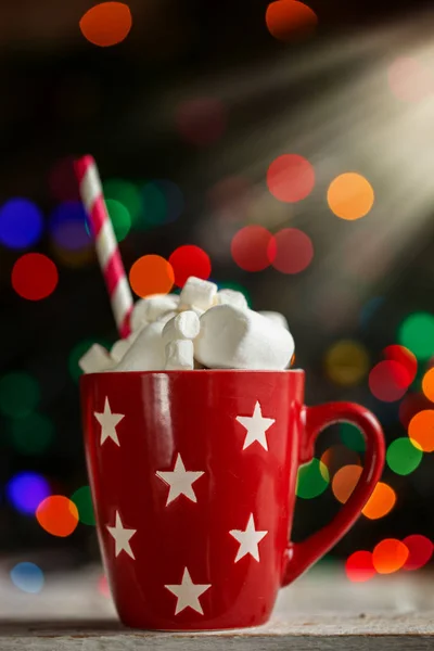 Red cup of hot cocoa with marshmallows and candy canes a colorful bokeh background with beautiful Christmas lights — Stock Photo, Image