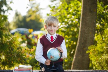 Sevimli öğrenci kitap ve açık havada üzerinde dünya ile. Çocuklar için eğitim. Geri okul kavramı.