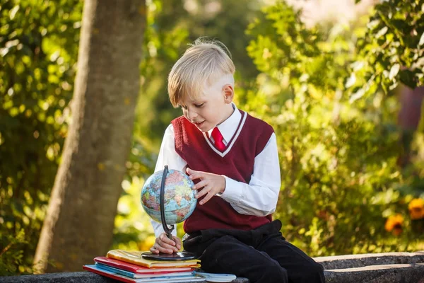 Bedårande skolpojke med böcker och globe på utomhus. Utbildning för barn. Tillbaka till skolan-konceptet. — Stockfoto