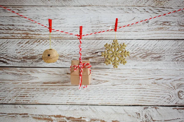 Рождественские украшения висят на шнуре на белом деревянном фоне . — стоковое фото