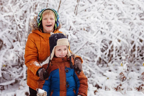 Dwa małe dzieci, chłopak braci bawiąc się na zewnątrz podczas snowfa — Zdjęcie stockowe
