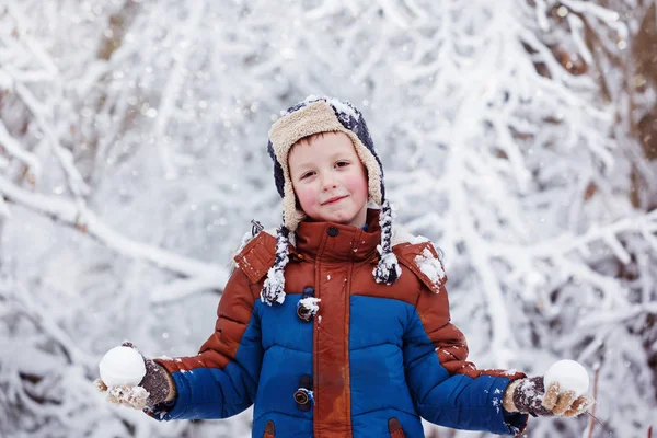 Cute little boy, kid in winter clothes walking under the snow — Stock Photo, Image