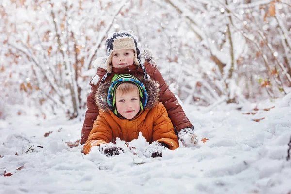 Dwa małe dzieci, chłopak braci gry i leżącego śniegu bas — Zdjęcie stockowe