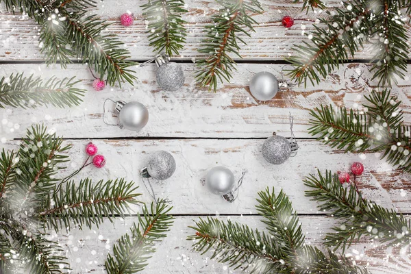 Рождественский фон с еловой веткой и серебряным шаром на белом деревянном столе . — стоковое фото