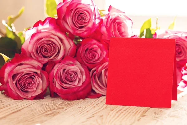 Чистая красная бумажная карточка на день святого Валентина, матери или женщины. Фон с розовыми розами — стоковое фото