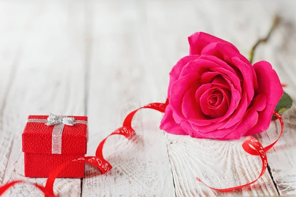 Mooie roze roos met de doos van de gift, Vakantiewoningen aanwezig op witte houten achtergrond. — Stockfoto