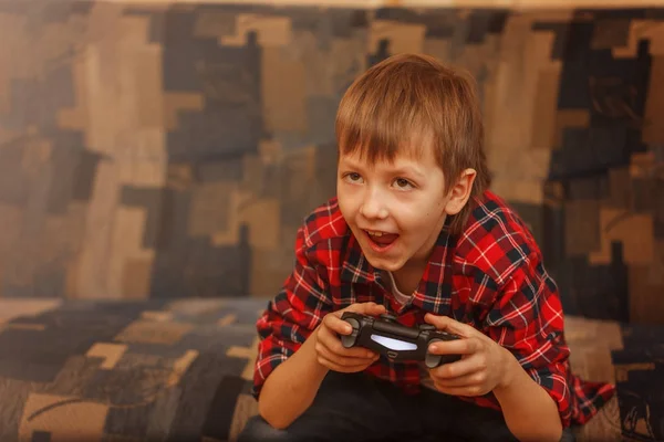 Joven niño sosteniendo gamepad y jugando videojuegos — Foto de Stock