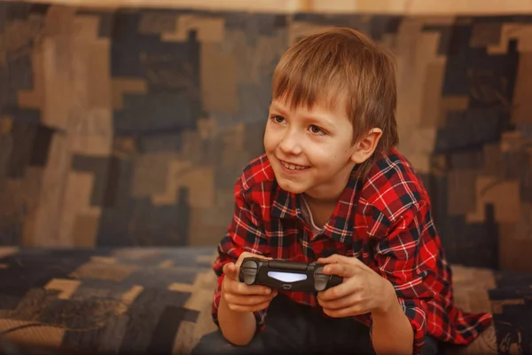 Jonge jongen gamepad te houden en het spelen van videospellen — Stockfoto