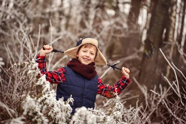 Portrait cute smiling boy in warm winter forest — Stock Photo, Image