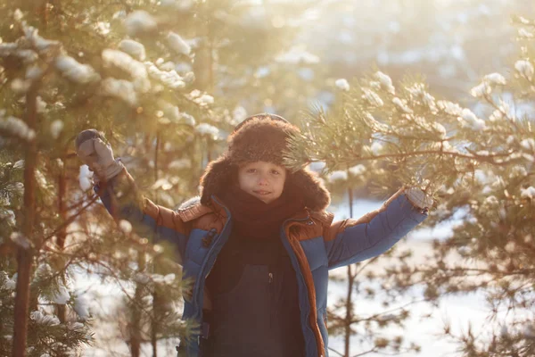Criança feliz andando em uma floresta de inverno em dia ensolarado — Fotografia de Stock