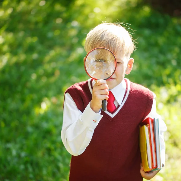 Porträtt liten skolpojke på natur bakgrund. Barn med böcker — Stockfoto