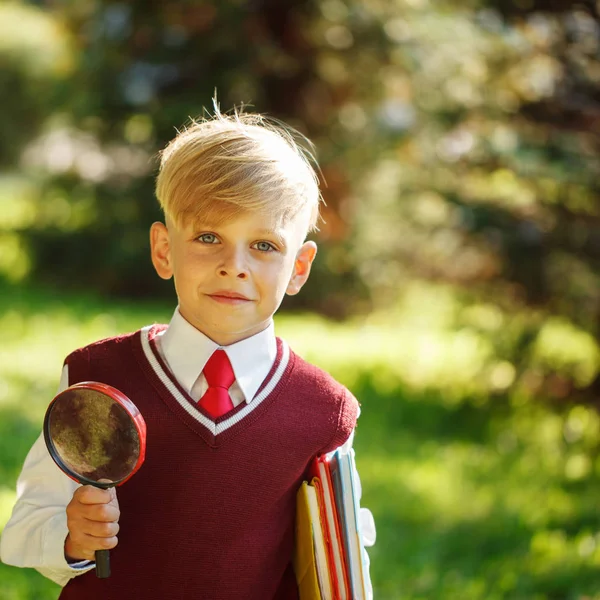 Dikey doğa arka plan üzerinde küçük okul çocuğu. Çocuk kitapları ile — Stok fotoğraf