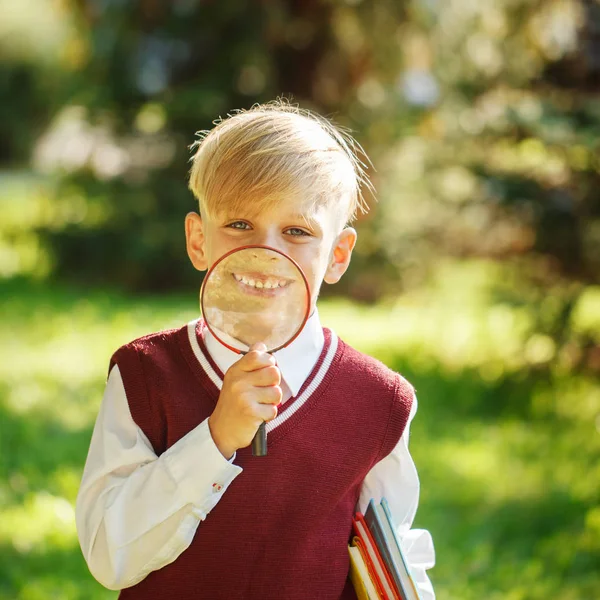 Ritratto piccolo scolaro su sfondo naturale. Bambino con libri — Foto Stock