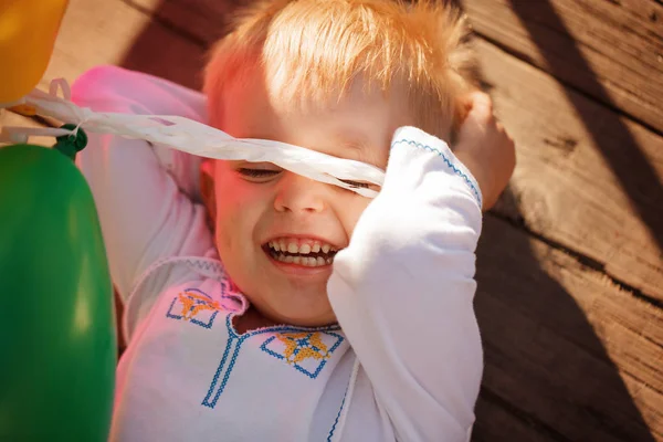 Little boy lying on around outdoor in summer day — Stock Photo, Image