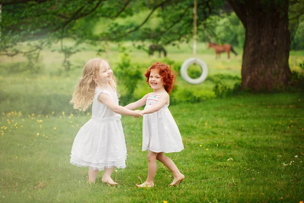 İki kız eğlenmek ve yaz aylarında parkta oynamak. — Stok fotoğraf