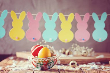 Paskalya Paskalya renkli yumurta sepet ve bunny garland ile bileşimi. Tonlu görüntü.