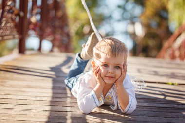 Küçük sarışın çocuk sokakta güneşli yaz günde yalan