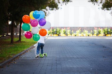 Renkli balloonsriding bir scooter bir avuç mutlu çocuk. Arkadan Görünüm