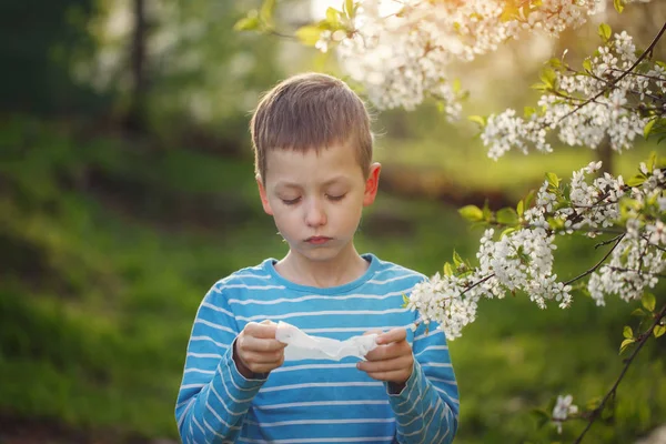 Концепция Аллергии Мальчик Сморкается Рядом Цветущими Цветами — стоковое фото